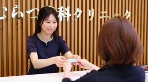 受付で治療費の精算をする様子